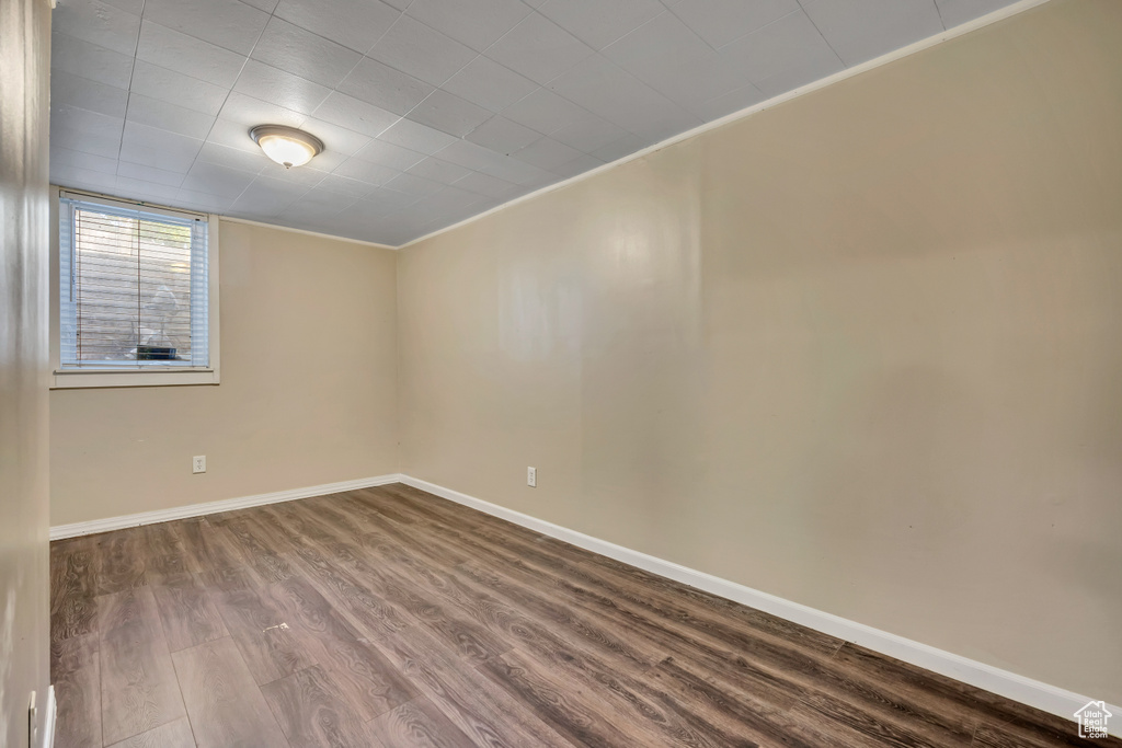Spare room with dark wood-type flooring and crown molding
