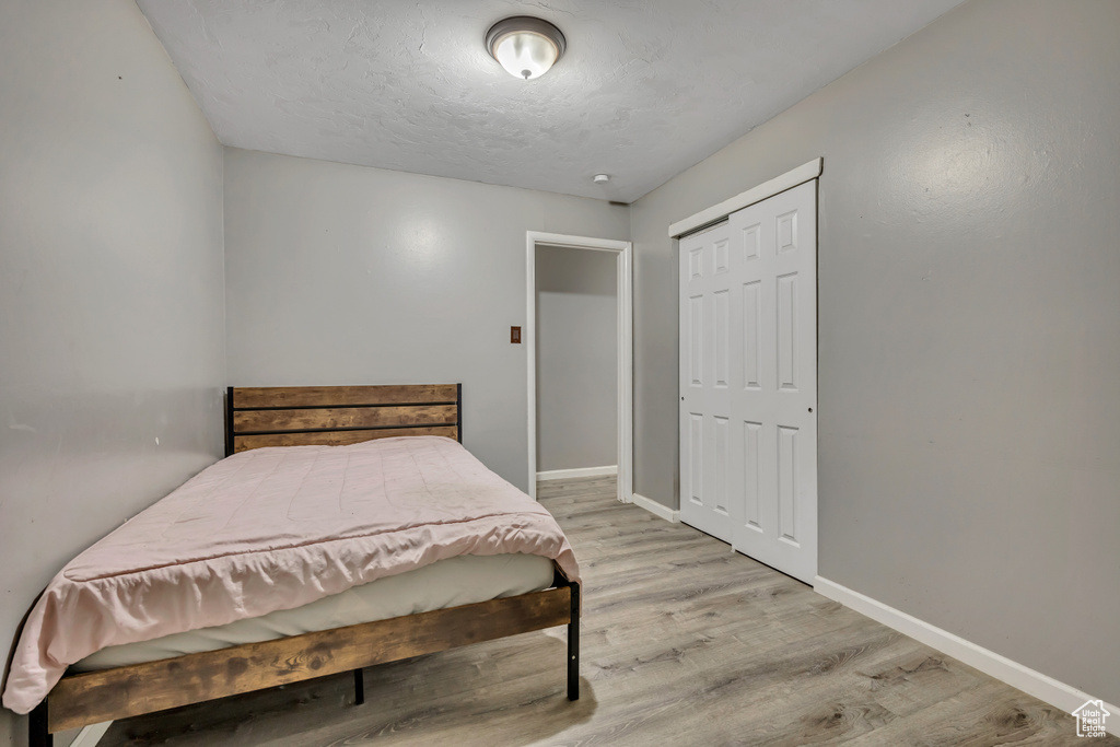 Bedroom with light wood-style flooring and a closet
