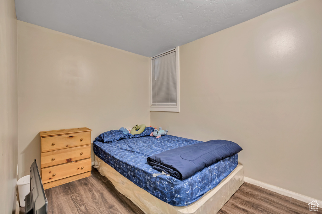 Bedroom with wood finished floors and baseboards