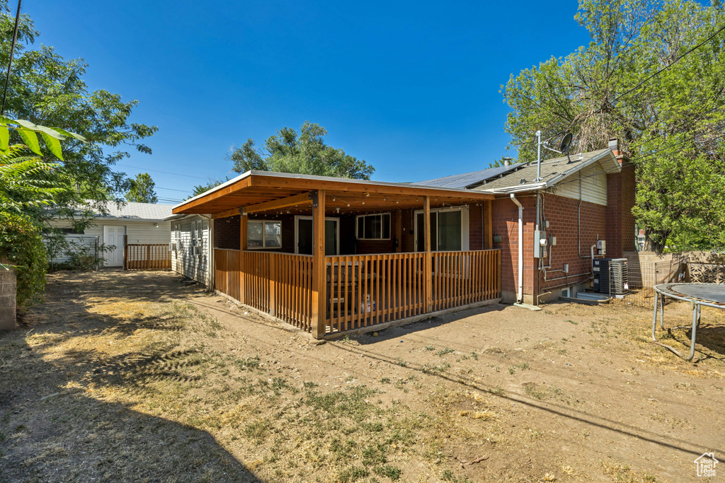 View of front of house with a trampoline, brick siding, and roof mounted solar panels