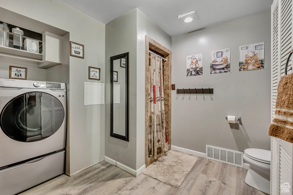 Washroom with washer / clothes dryer and wood finished floors