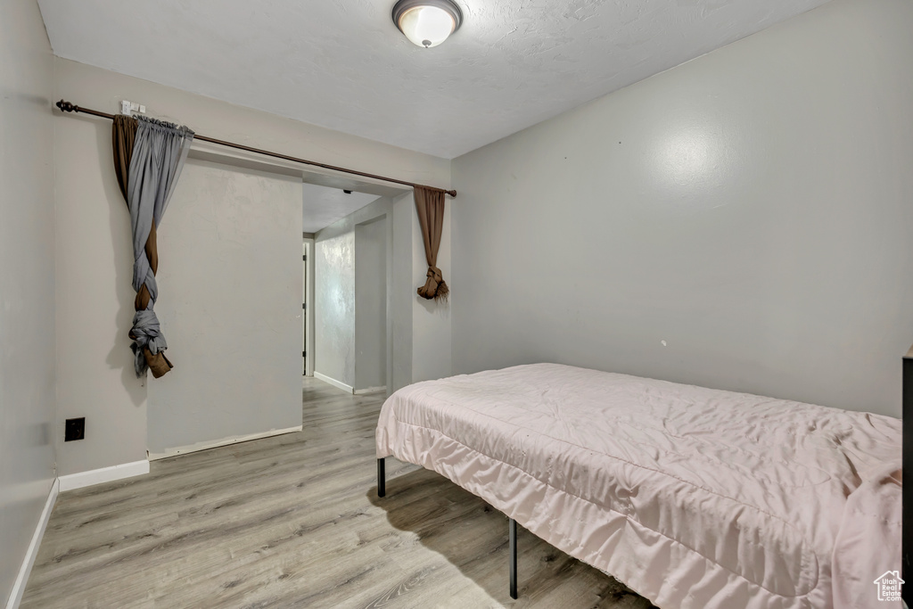 Bedroom with wood finished floors and baseboards