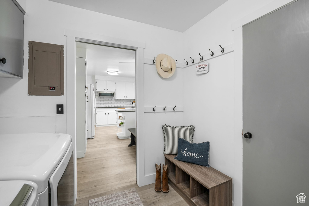 Mudroom featuring washer and dryer, light wood-style floors, and electric panel