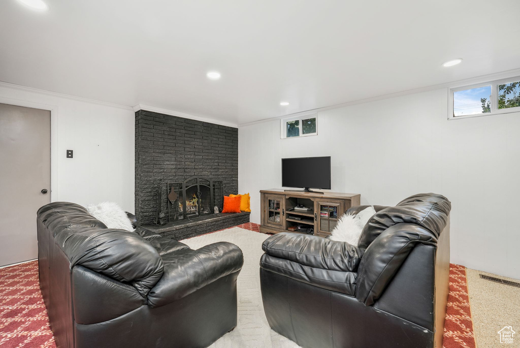 Living room featuring a brick fireplace, recessed lighting, and crown molding