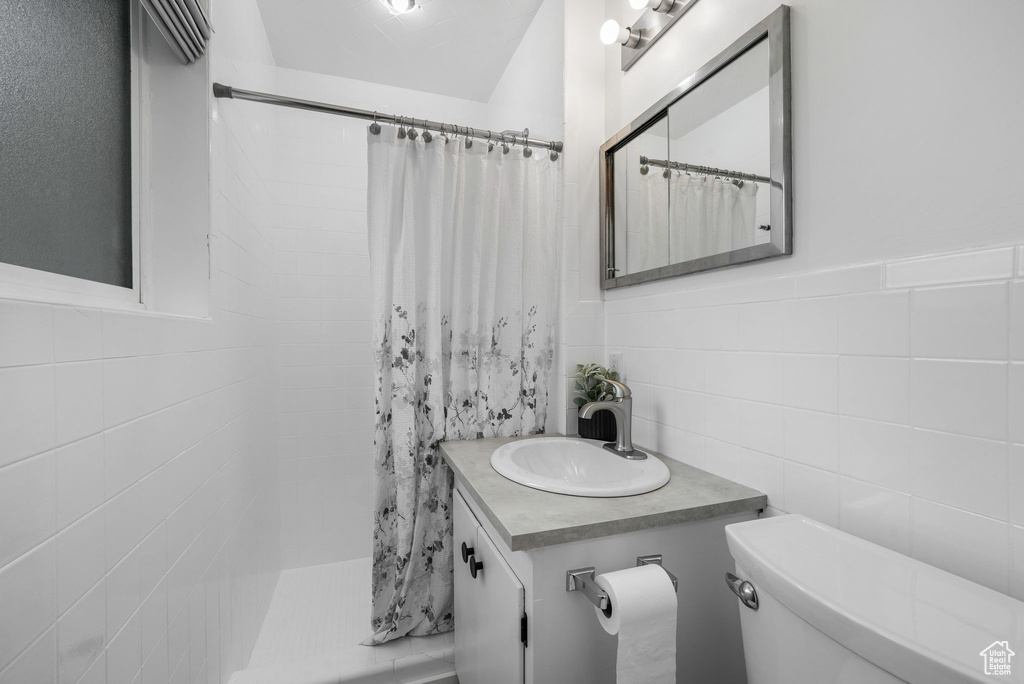 Bathroom featuring tile walls, vanity, and a shower with curtain