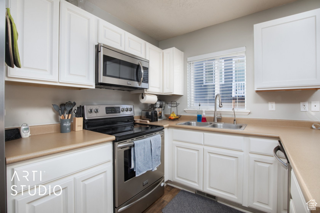 Kitchen featuring appliances with stainless steel finishes and white cabinets