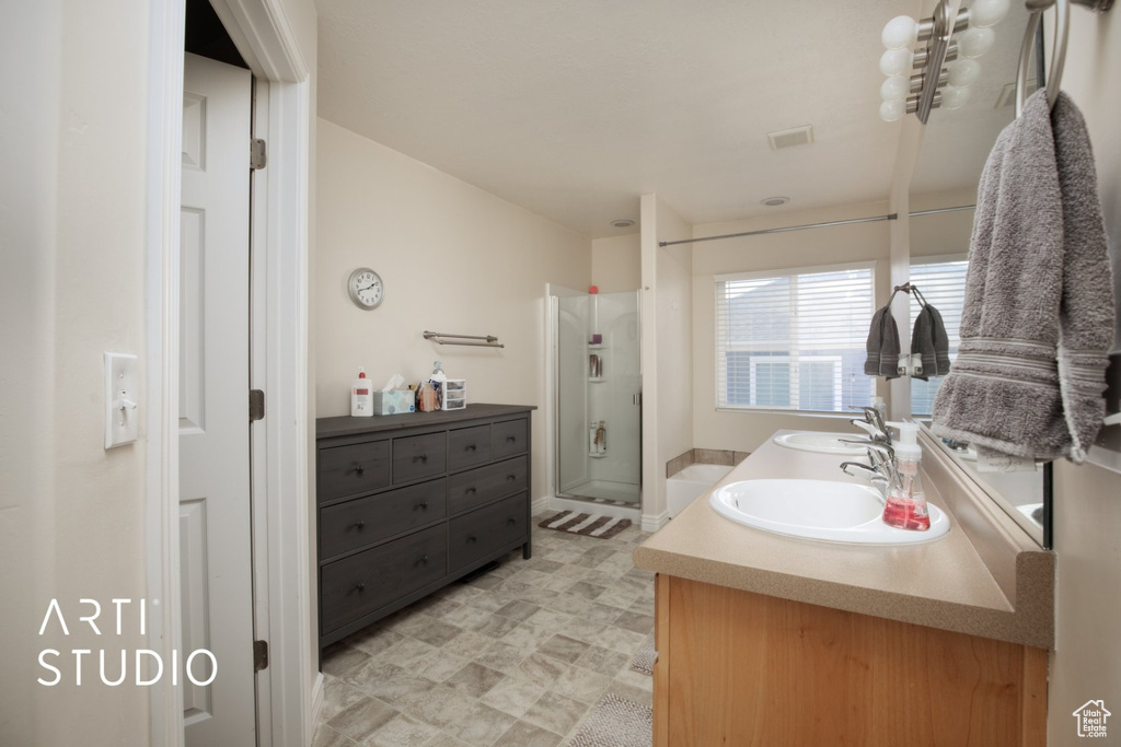 Full bath featuring double vanity, a shower stall, and tile patterned floors