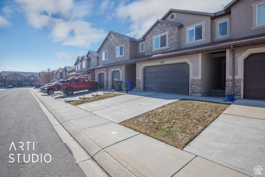 View of asphalt road featuring a residential view and sidewalks