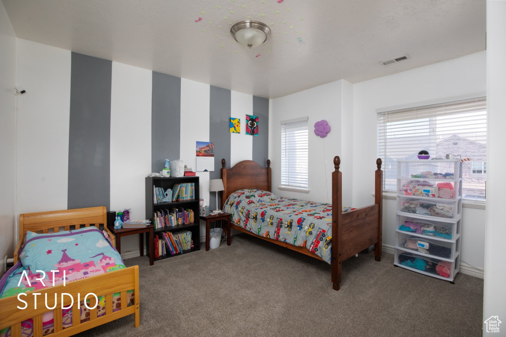 Bedroom featuring multiple windows and carpet flooring