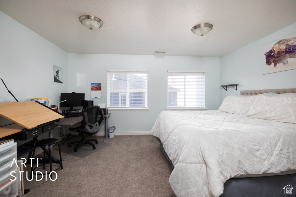 Bedroom with carpet floors and a desk