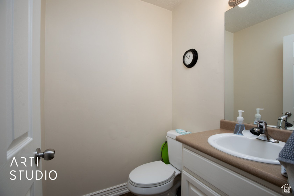 Half bathroom featuring vanity and toilet