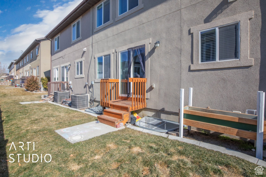 Rear view of house featuring stucco siding, a yard, and a residential view