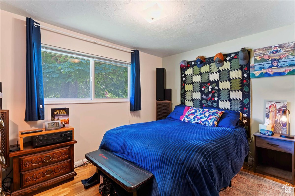 Bedroom with wood finished floors and a textured ceiling