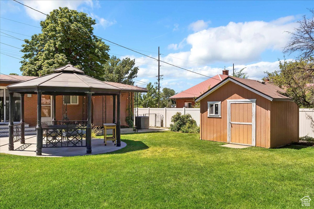 View of yard featuring a gazebo, a storage unit, and a patio