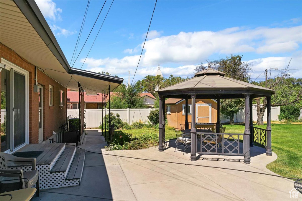 Fenced backyard featuring a gazebo and a patio area