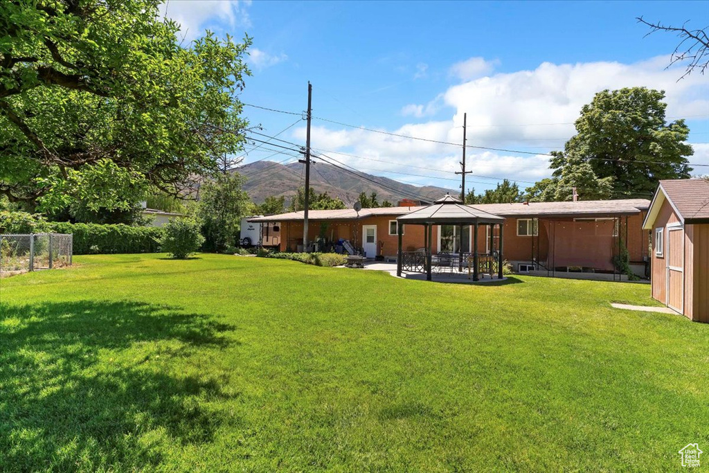 View of grassy yard featuring a gazebo and a mountain view