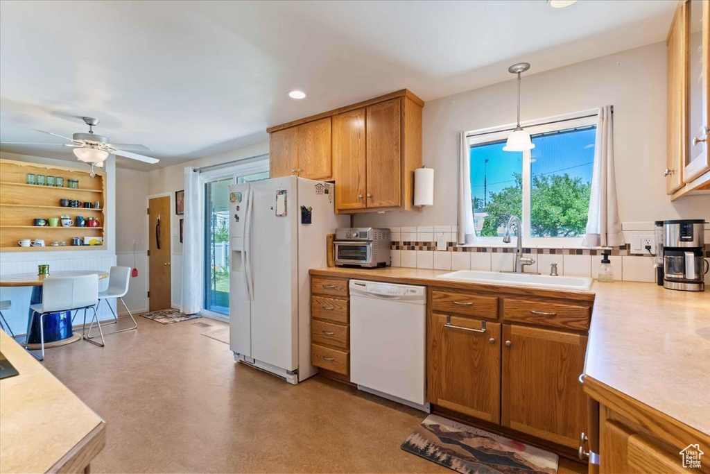 Kitchen featuring light countertops, white appliances, brown cabinets, tasteful backsplash, and recessed lighting