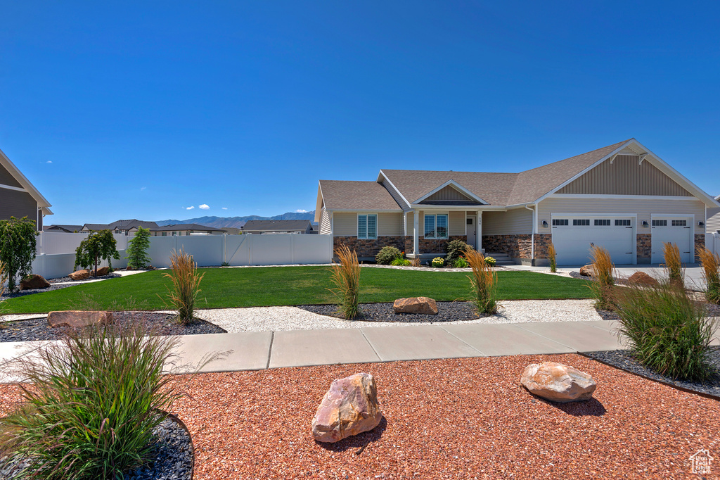 Craftsman house with stone siding, a shingled roof, and an attached garage