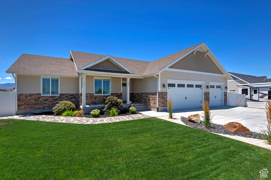 Craftsman house with roof with shingles, stone siding, an attached garage, driveway, and a gate