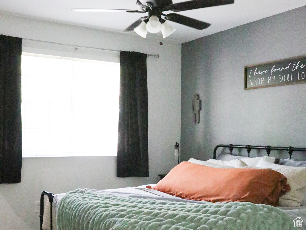 Carpeted bedroom with a ceiling fan and baseboards