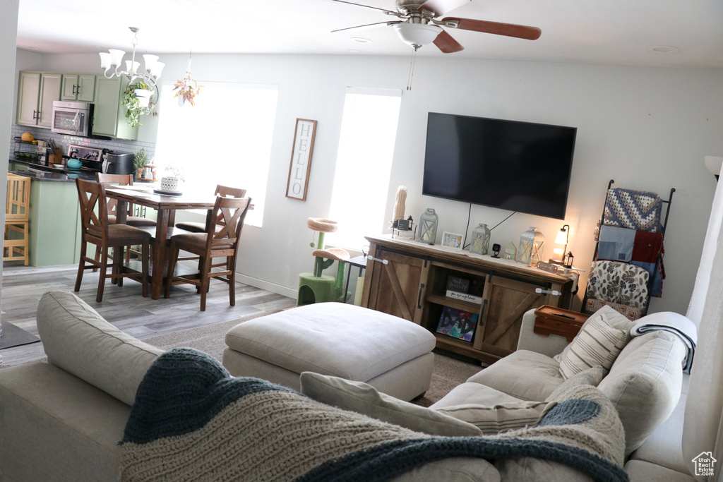 Living room with ceiling fan and light wood finished floors