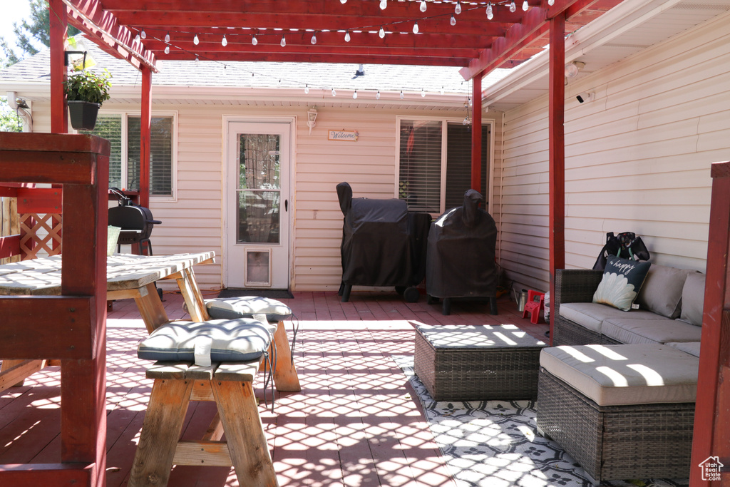 Wooden terrace with outdoor lounge area, a pergola, area for grilling, and a patio area
