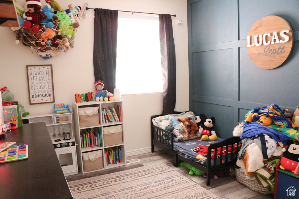 Bedroom with wood finished floors and baseboards