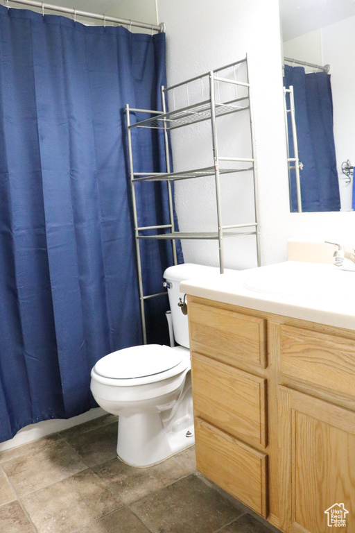 Bathroom with vanity, stone finish flooring, and a shower with curtain