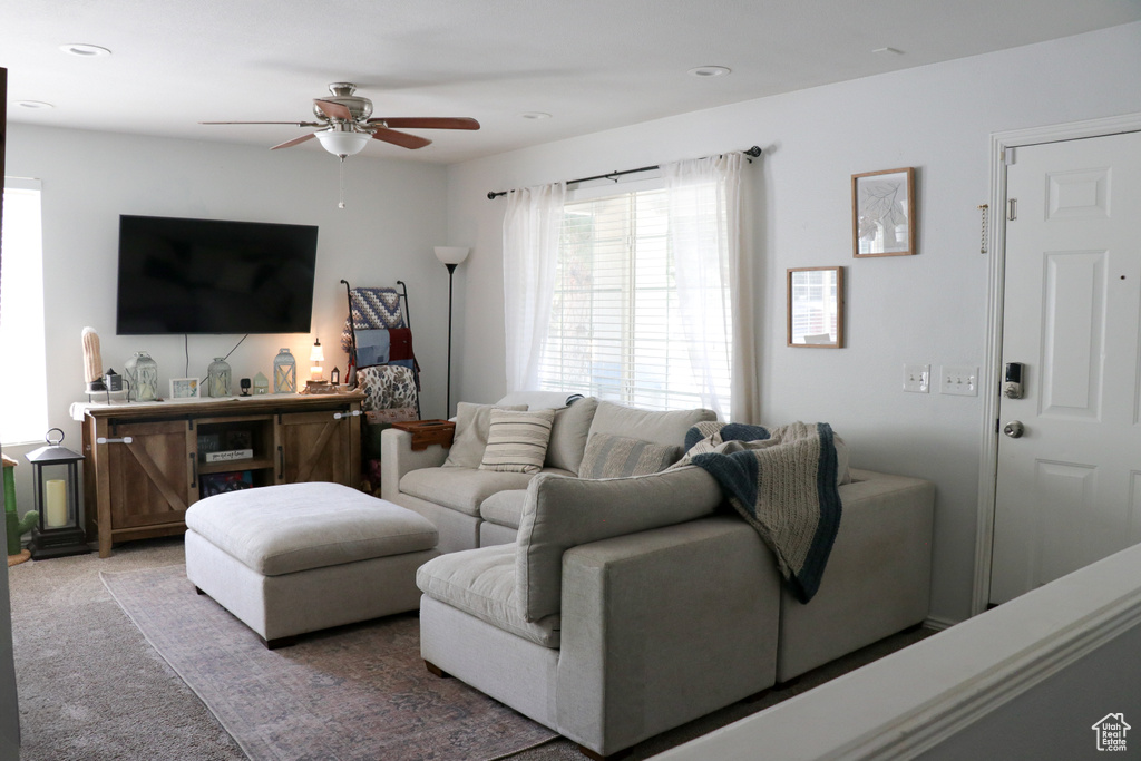 Living area with a ceiling fan, light colored carpet, and recessed lighting