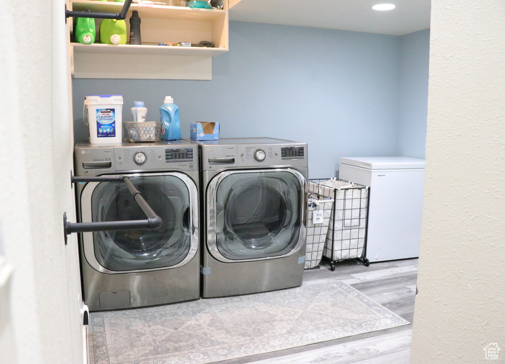 Laundry area featuring separate washer and dryer and wood finished floors