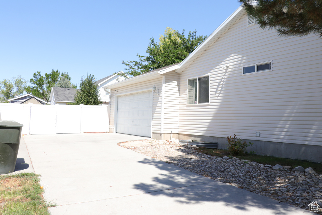 View of property exterior featuring driveway and a garage