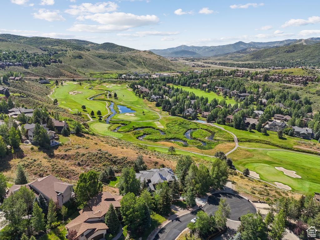 Aerial view of property\'s location featuring a golf club, a water and mountain view, and nearby suburban area
