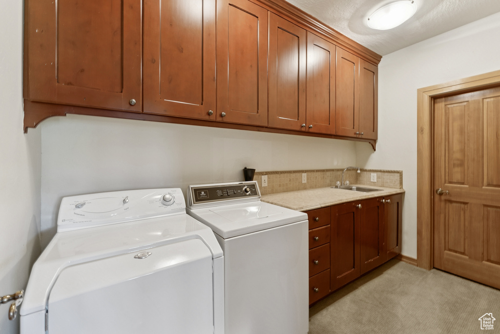 Laundry room featuring cabinet space, independent washer and dryer, and light carpet