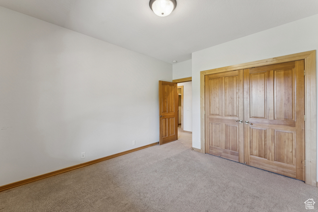 Unfurnished bedroom with carpet and baseboards