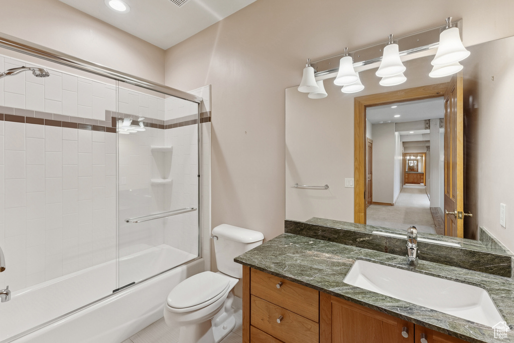 Bathroom featuring vanity and shower / bath combination with glass door
