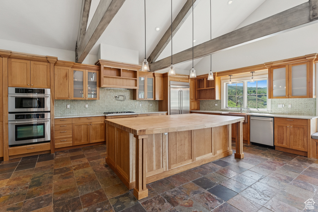 Kitchen with open shelves, wood counters, stone tile flooring, a kitchen island, and high vaulted ceiling