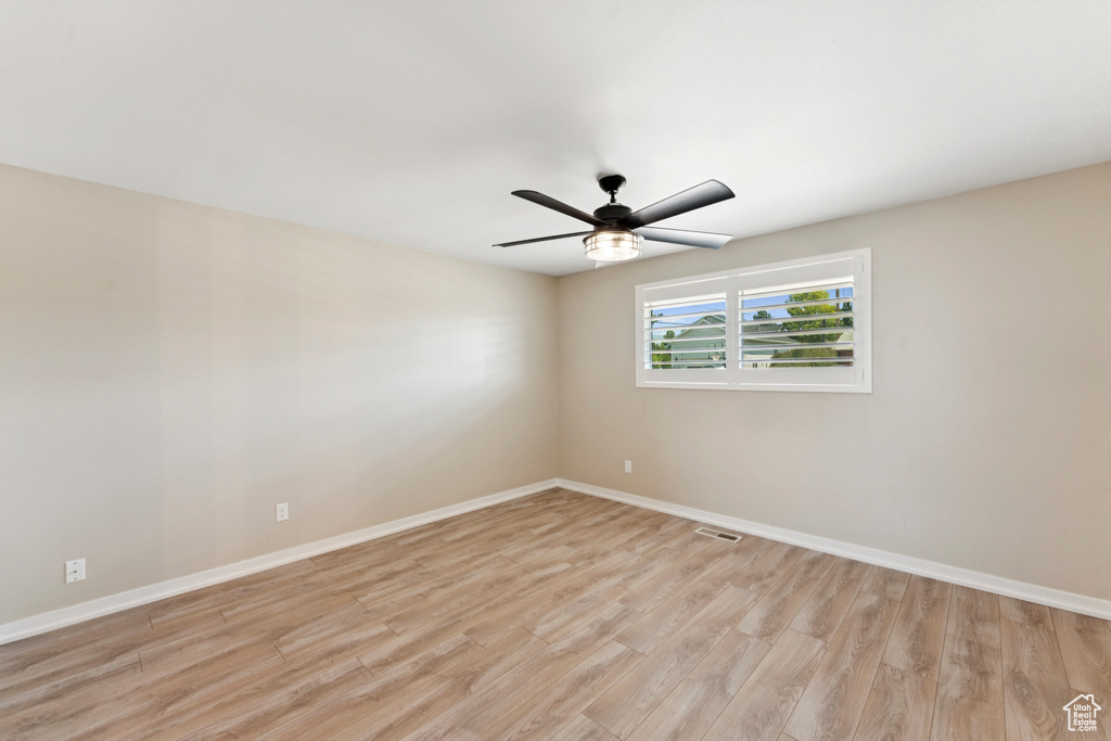 Unfurnished room featuring light wood-style floors and ceiling fan