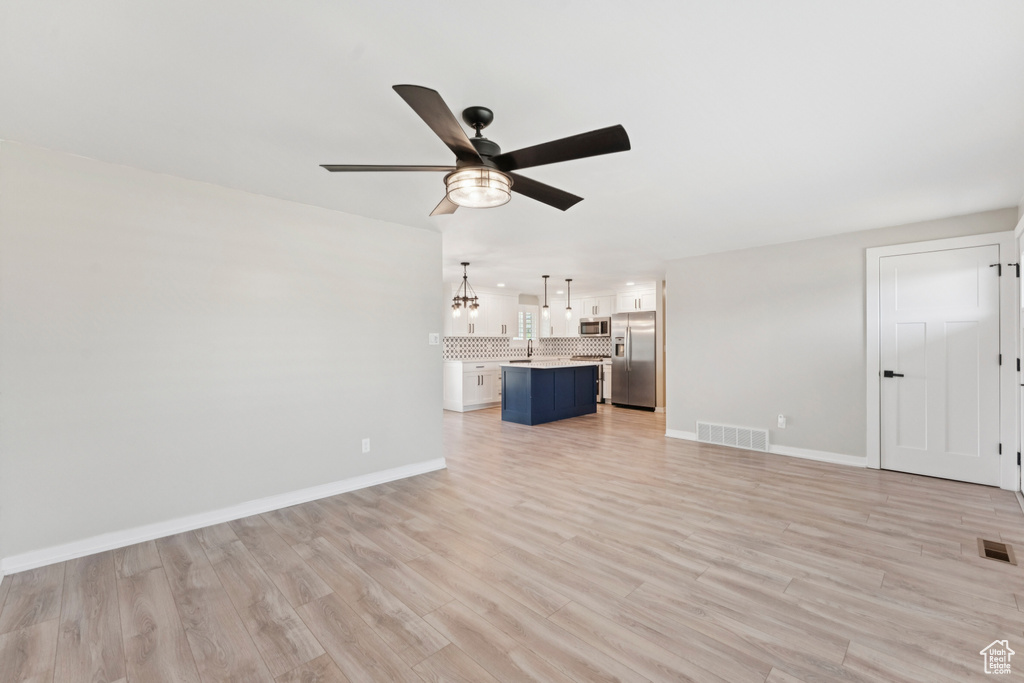 Unfurnished living room featuring a ceiling fan, light wood-type flooring, and recessed lighting