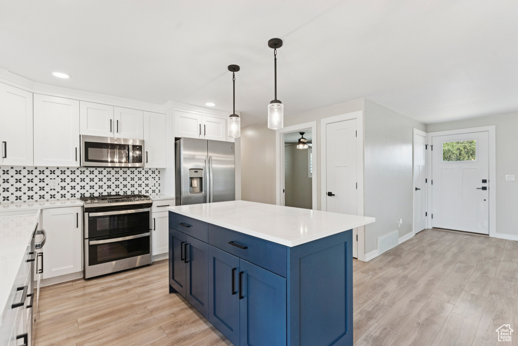 Kitchen with stainless steel appliances, white cabinetry, a ceiling fan, light wood finished floors, and recessed lighting