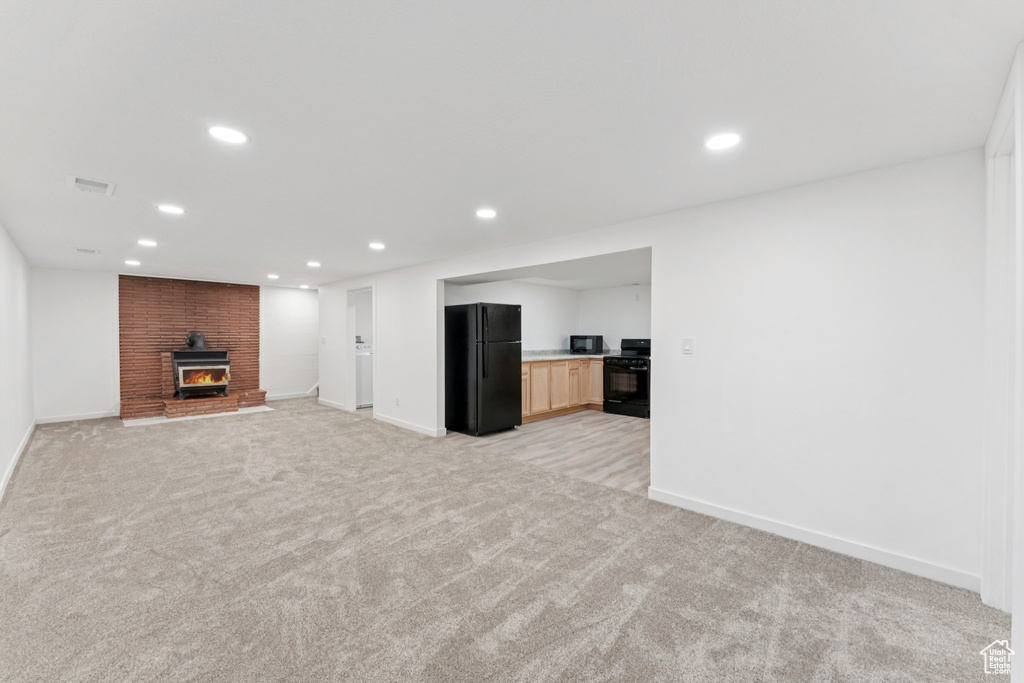 Unfurnished living room featuring light colored carpet, recessed lighting, and a fireplace