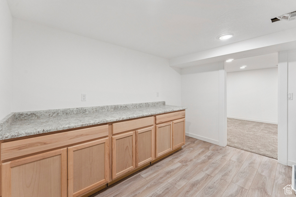 Kitchen featuring light brown cabinets, light wood-style flooring, light countertops, and recessed lighting