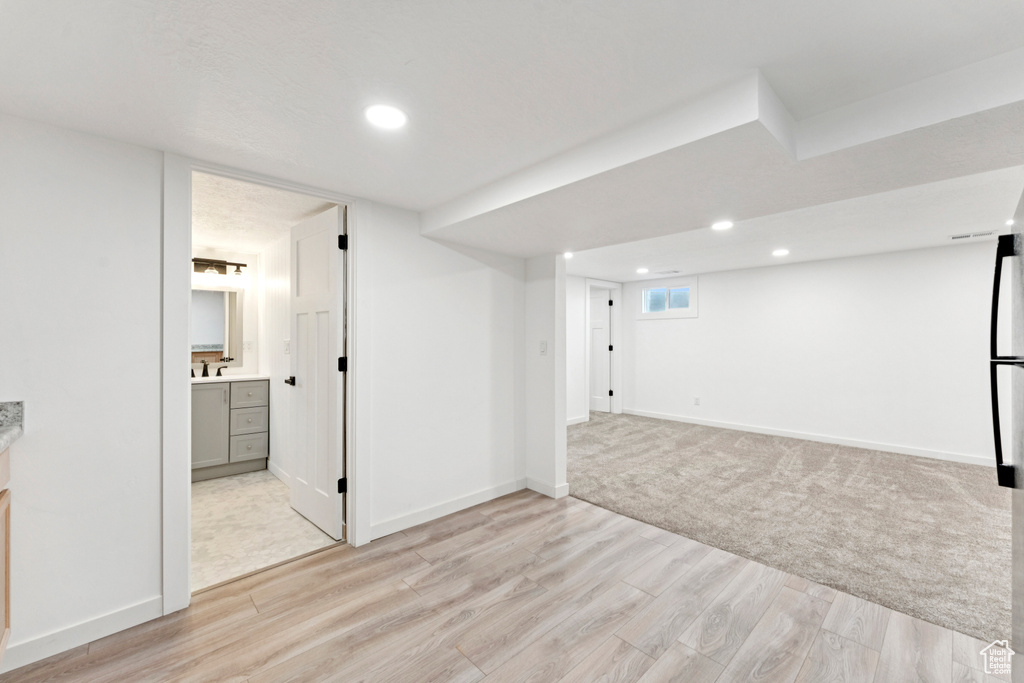 Below grade area featuring recessed lighting and light wood-style floors
