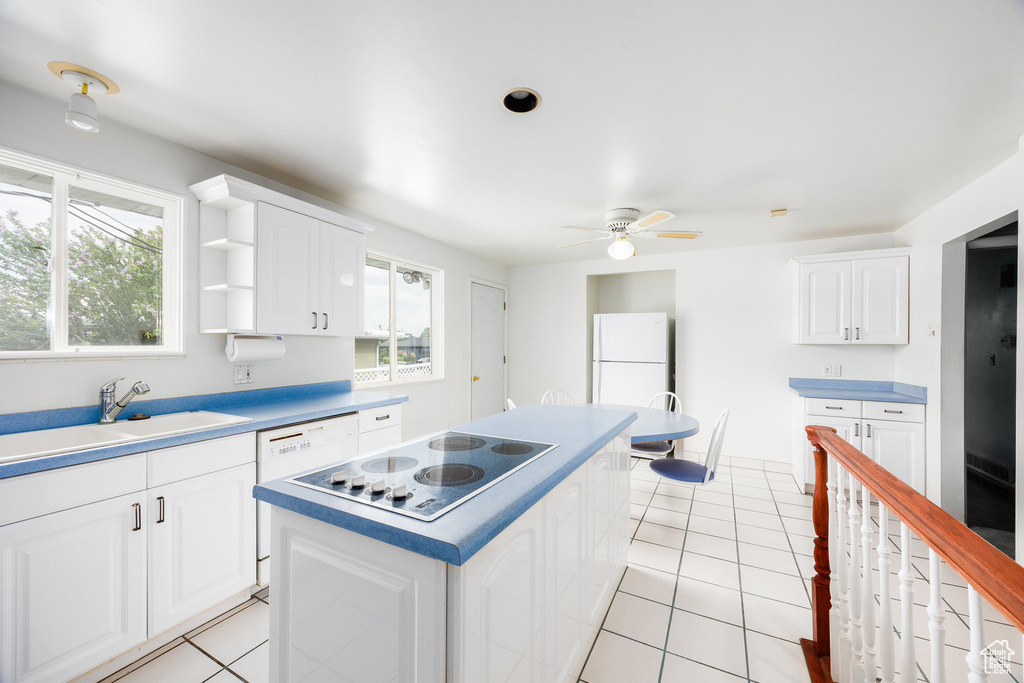 Kitchen featuring a center island, white appliances, a ceiling fan, and light tile patterned flooring