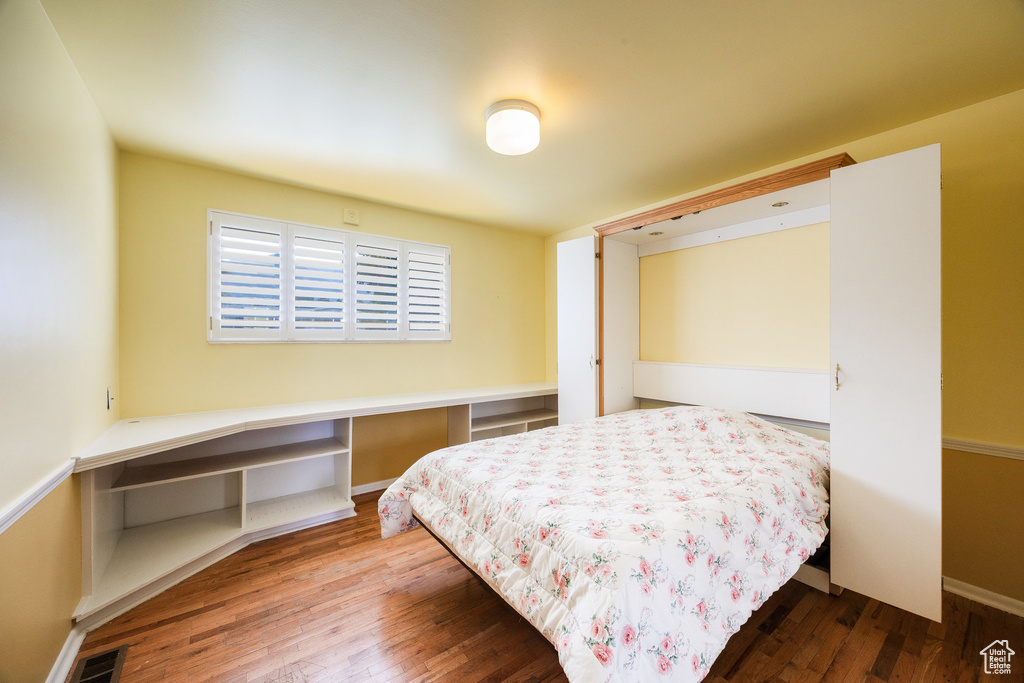 Bedroom featuring wood-type flooring and baseboards