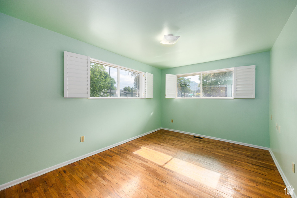 Spare room featuring wood finished floors and baseboards