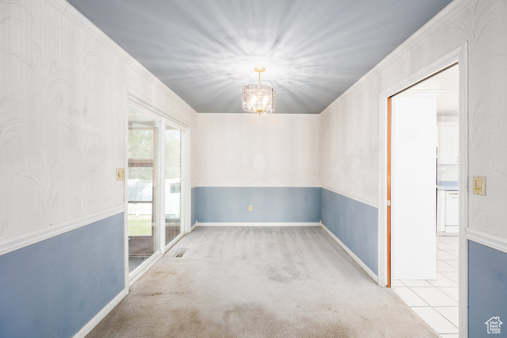 Unfurnished room with a chandelier and carpet flooring