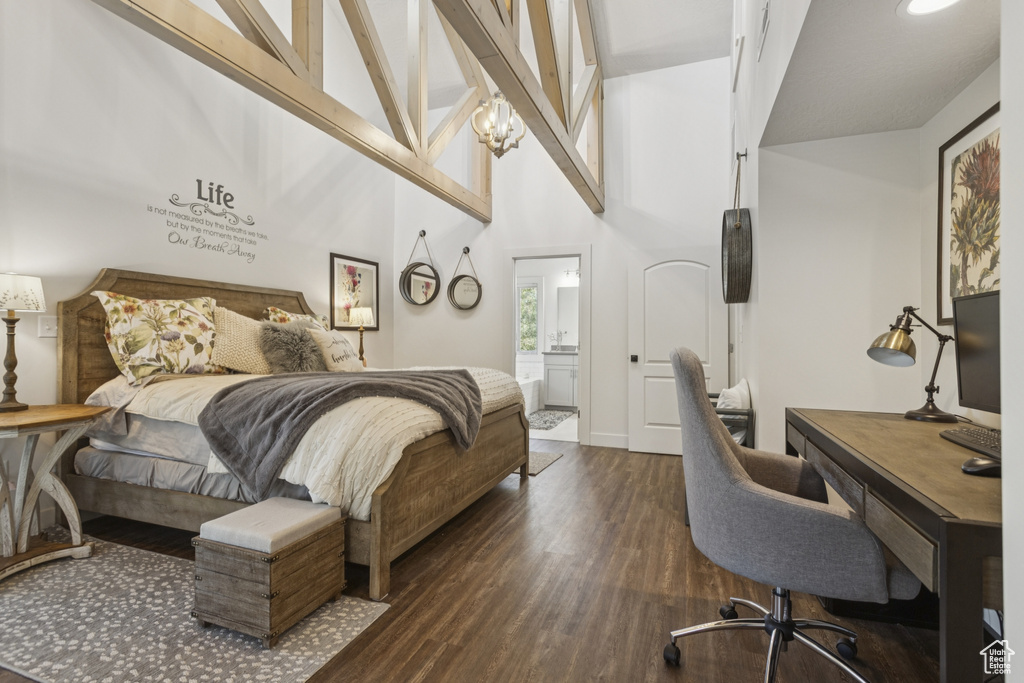 Bedroom with dark wood-style flooring, a desk, a towering ceiling, and ensuite bathroom