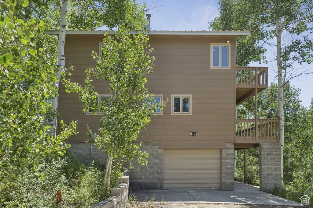 Back of house featuring an attached garage and driveway