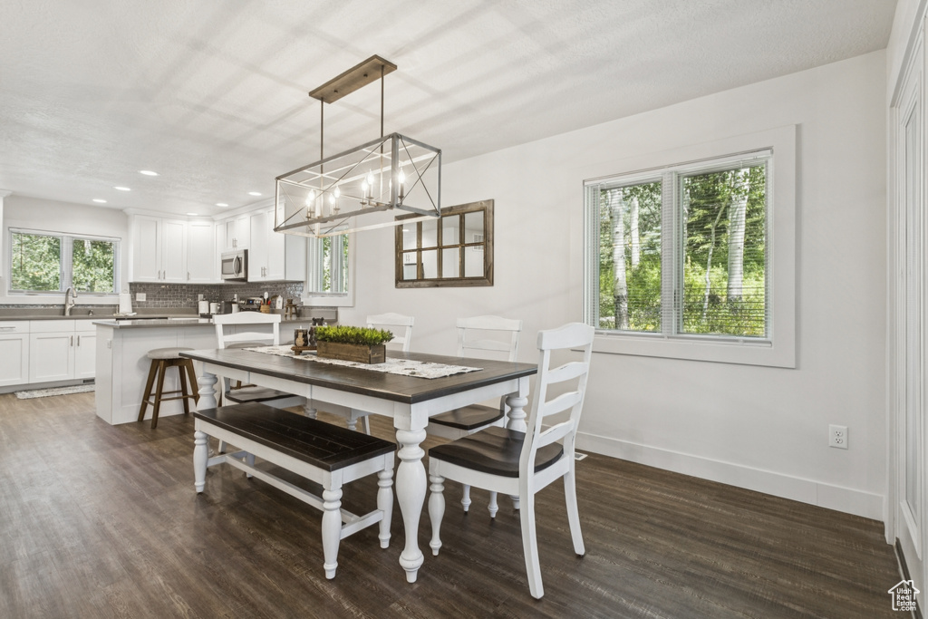 Dining space with dark wood-style floors, a chandelier, and recessed lighting