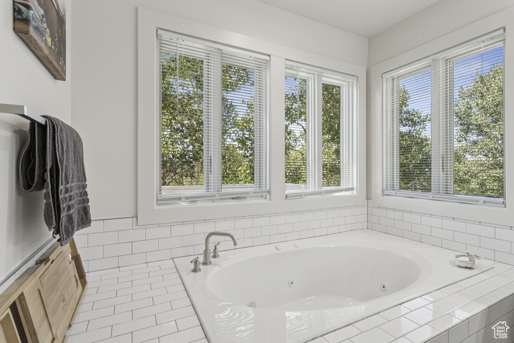 Full bathroom with a jetted tub and tile patterned flooring